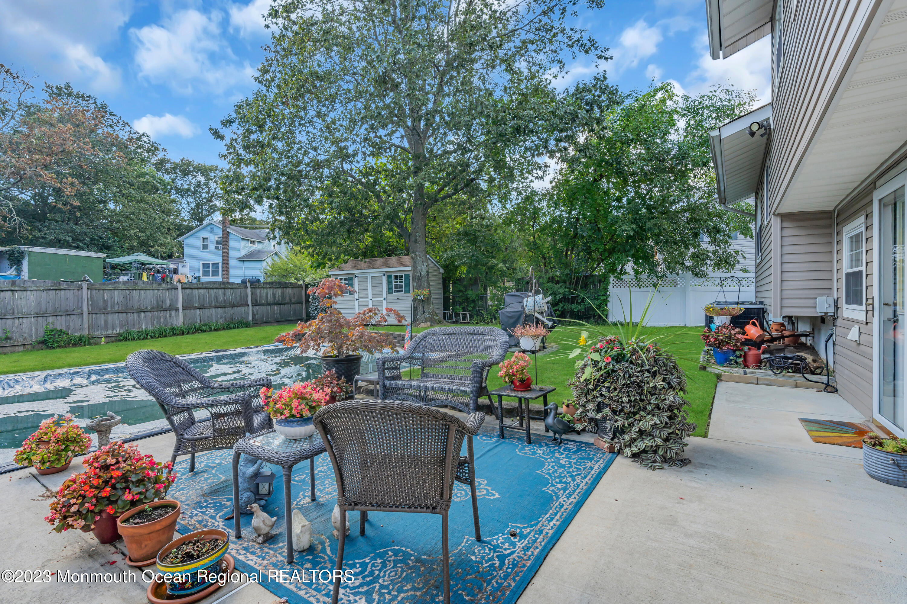 41 Citadel Drive Jackson, NJ 08527 - Photo 37 of 46 a view of a patio with table and chairs potted plants and a wooden fence