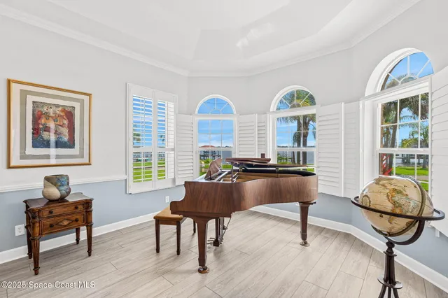 a large white kitchen with a stove a sink dishwasher a dining table and chairs with wooden floor