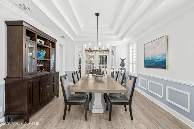 a kitchen with stainless steel appliances kitchen island granite countertop a table chairs and a wooden floor