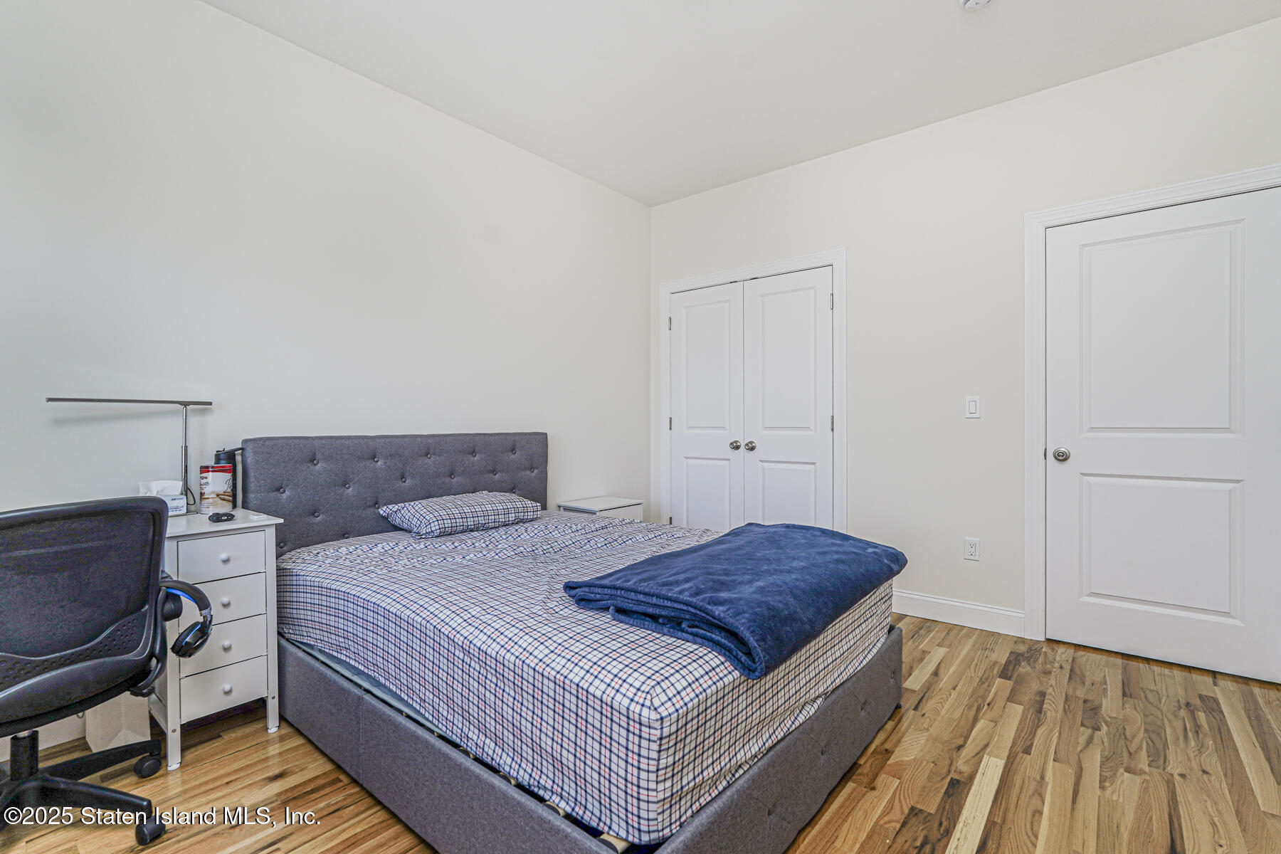 25 Ardmore Avenue Staten Island, NY 10314 - Photo 15 of 27 a bedroom with a bed and wooden floor