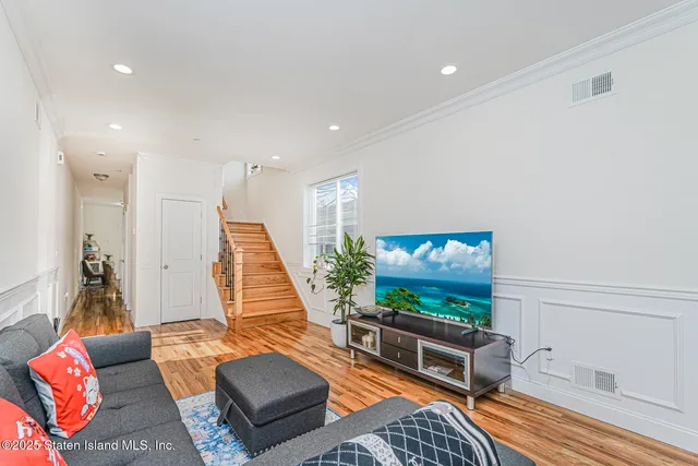 a living room with furniture flat screen tv and a large window