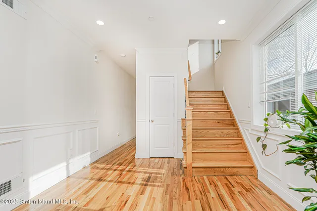 a view of a hallway with wooden floor and staircase