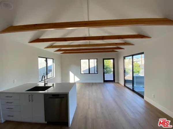 a view of a hallway with wooden floor and cabinet