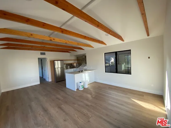 a view of a room with wooden floor and a window