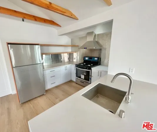 a kitchen with stainless steel appliances a refrigerator and a stove top oven