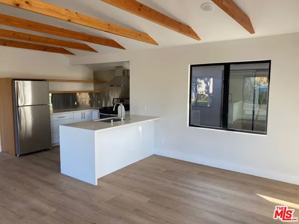 a kitchen with stainless steel appliances a refrigerator and a stove top oven