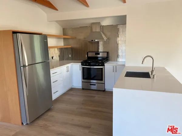 a kitchen with stainless steel appliances a refrigerator stove and sink