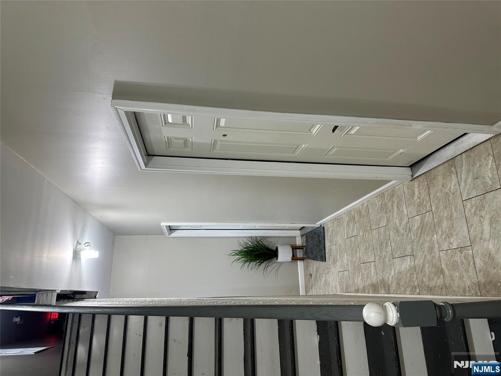 267 Ellison Street Paterson, NJ 07501 - Photo 7 of 16 a view of a hallway with wooden floor and a bathroom view