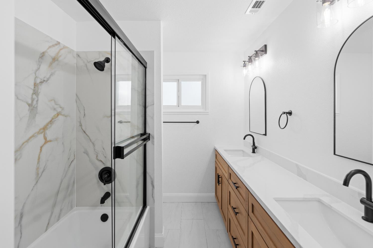 420 Bellevue Road Merced, CA 95348 - Photo 53 of 75 a bathroom with a double vanity sink a mirror a bathtub and shower