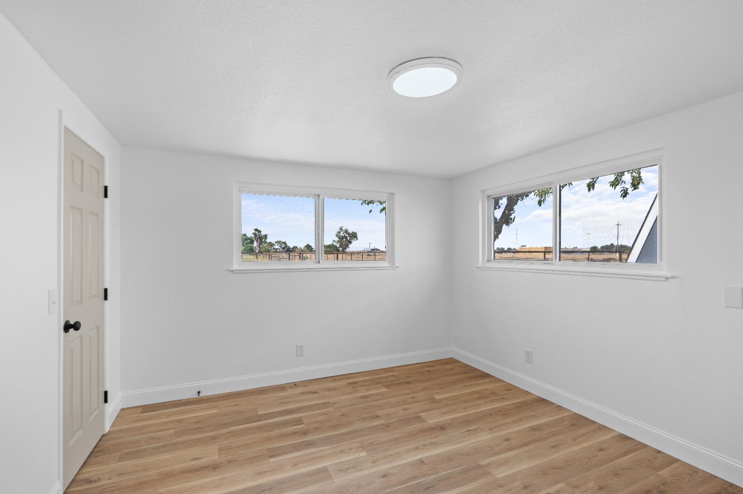 420 Bellevue Road Merced, CA 95348 - Photo 61 of 75 a view of an empty room with wooden floor and a window