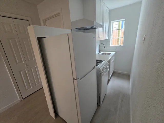 a utility room with refrigerator and washer
