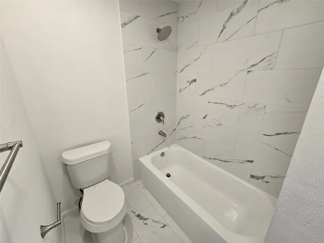 a white bath tub sitting next to a toilet