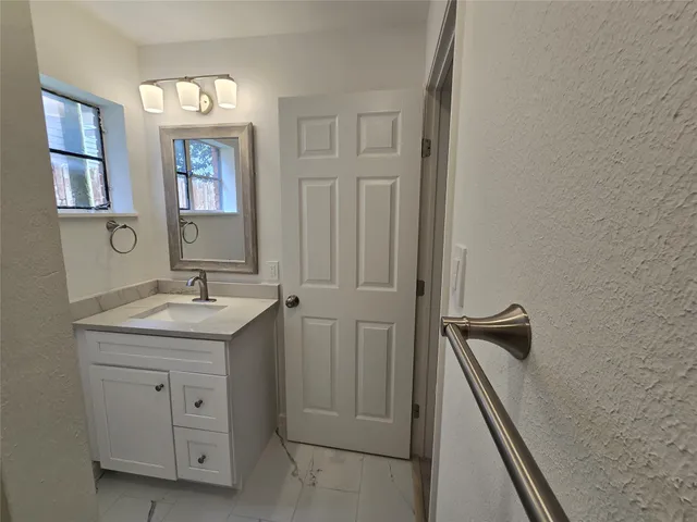a bathroom with a granite countertop sink a toilet and a mirror