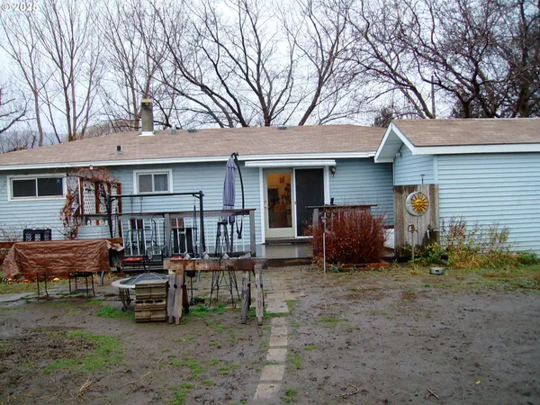a view of a chair and tables in the back yard of the house