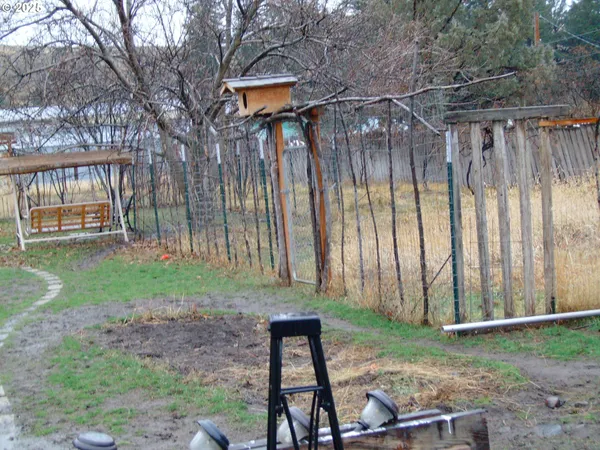 a backyard of a house with a garden and barbeque