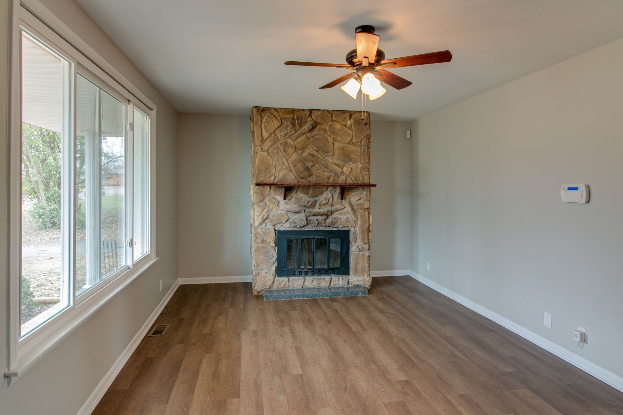 310 Burch Road Clarksville, TN 37042 - Photo 6 of 30 wooden floor fireplace and windows in an empty room