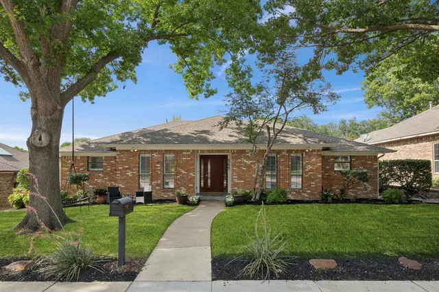a front view of a house with a garden and plants