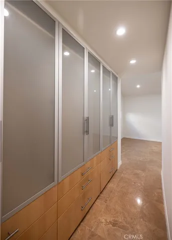 a view of a hallway with wooden floor and a bathroom