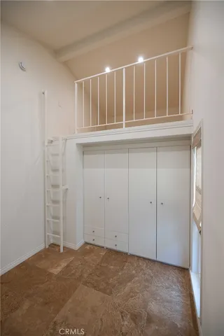 an empty room with kitchen and fireplace