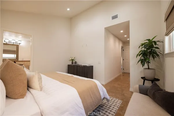 a bedroom with a bed and a potted plant
