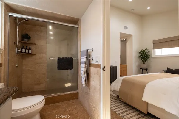 a bathroom with a granite countertop sink a toilet and shower