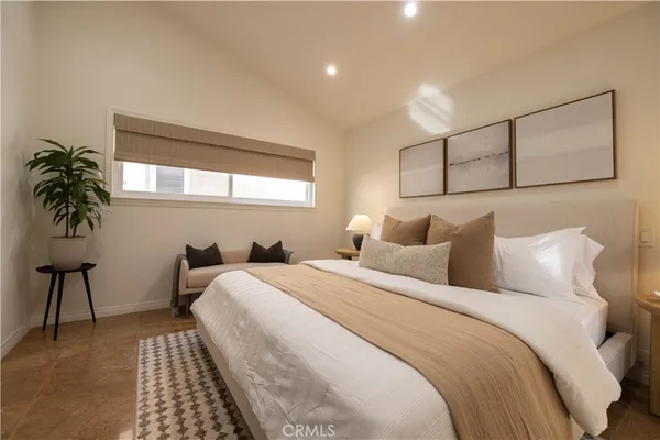 a bedroom with bed and a potted plant