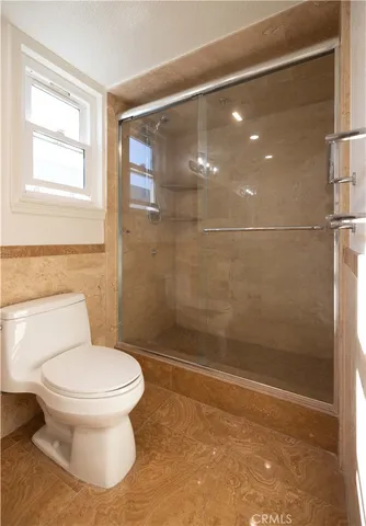 a bathroom with a toilet and a shower