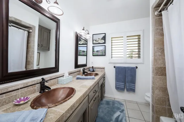 a bathroom with a granite countertop sink a mirror and a shower
