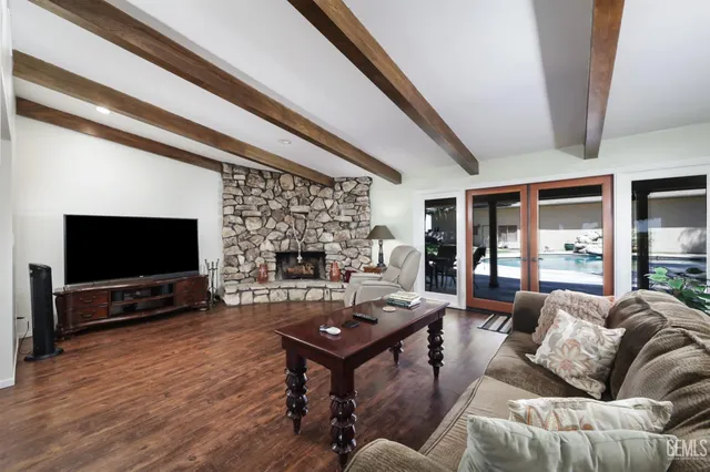 a living room with furniture a flat screen tv and a fireplace