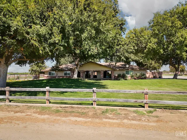 a view of a tennis ground with large trees