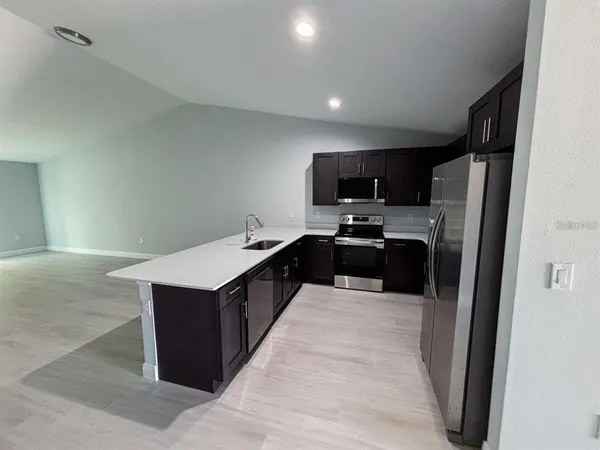 a kitchen with stainless steel appliances a refrigerator stove microwave and sink