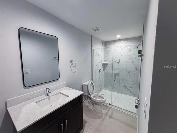 a bathroom with a bathtub shower sink mirror and toilet