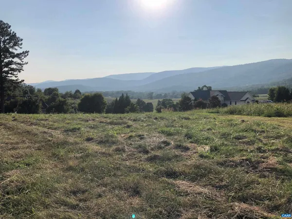 a view of a field with mountains in the background