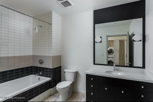 a bathroom with a sink a toilet a mirror and shower