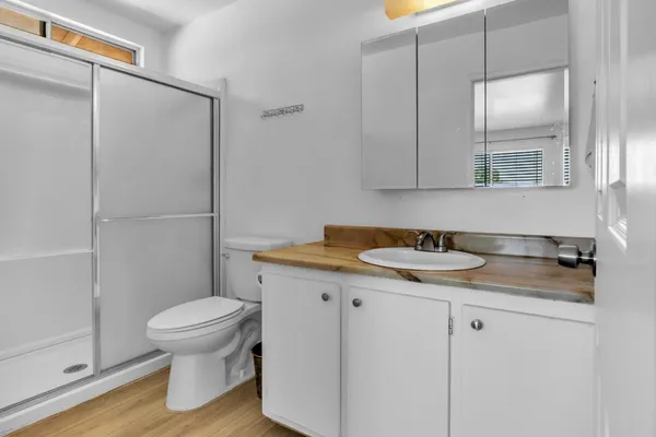 a bathroom with a granite countertop sink toilet and a mirror