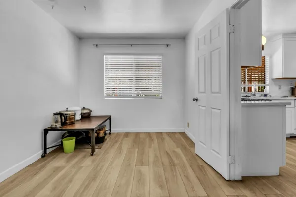 a view of a workspace with wooden floor and a window