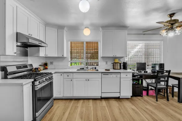 a kitchen with stainless steel appliances granite countertop a stove a sink dishwasher and a microwave oven with cabinets
