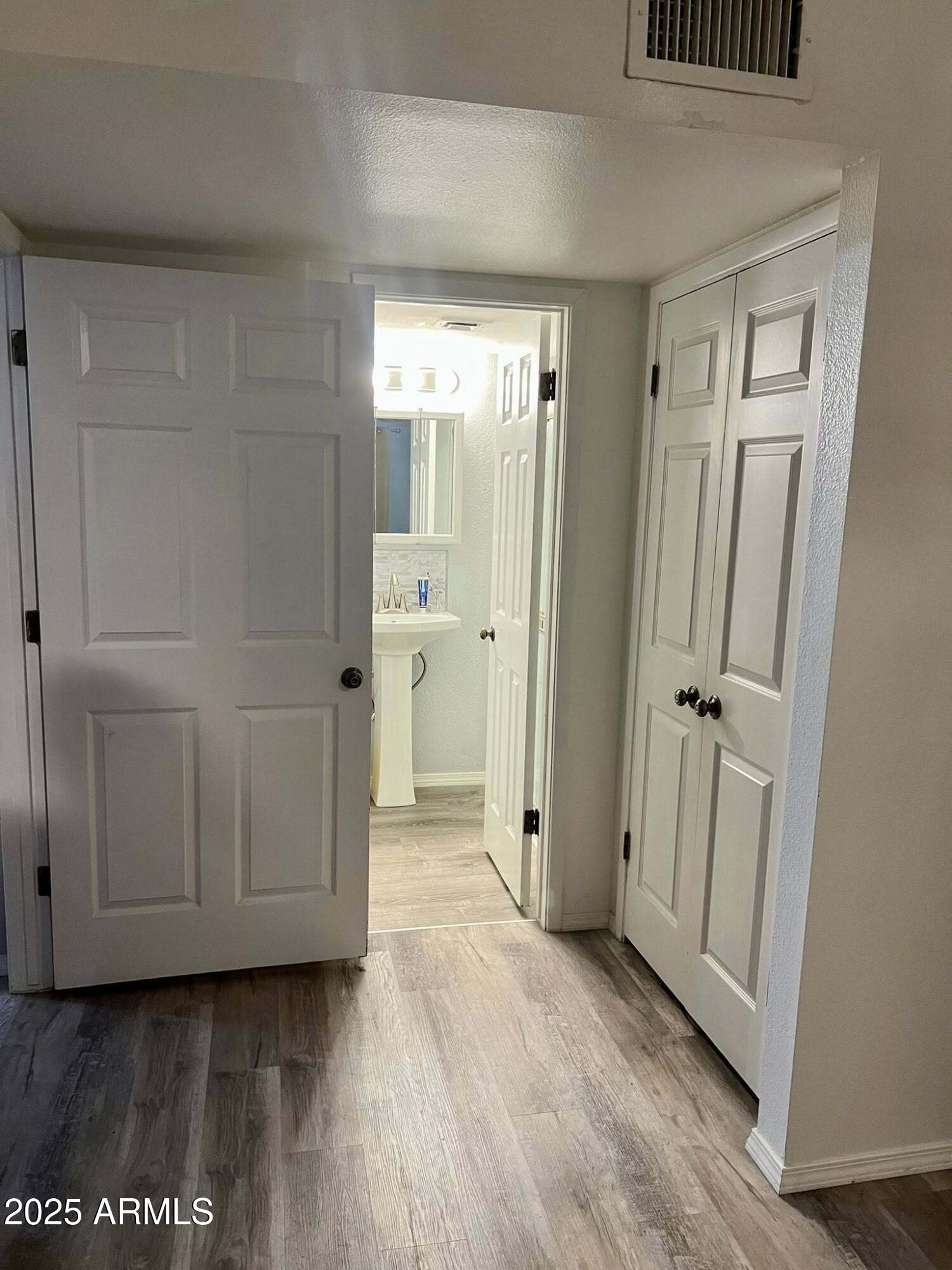 709 South Power Road, Unit 107 Mesa, AZ 85206 - Photo 16 of 26 a view of a hallway with wooden floor and cabinet