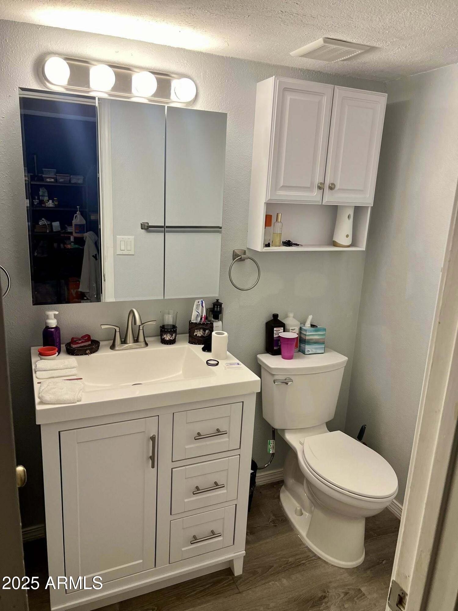 709 South Power Road, Unit 107 Mesa, AZ 85206 - Photo 22 of 26 a bathroom with a toilet sink and mirror