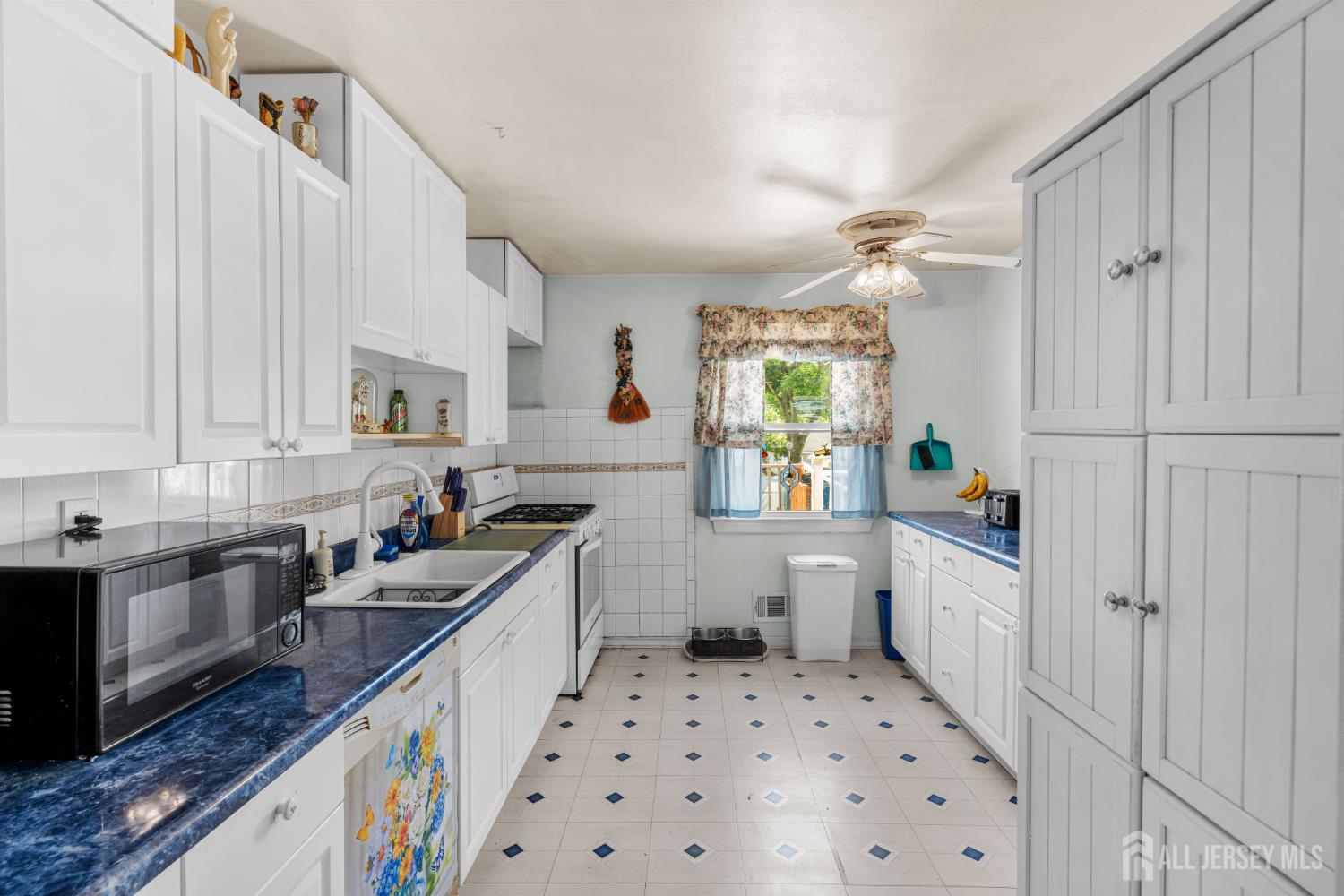245 4th Street Dunellen, NJ 08812 - Photo 9 of 27 a kitchen with a sink a stove a window and cabinets