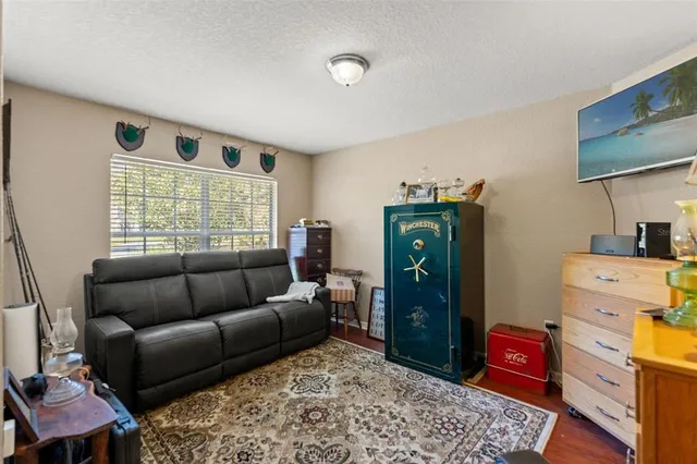 a living room with furniture a flat screen tv and a ceiling fan