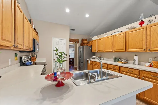 a kitchen with stainless steel appliances granite countertop a stove top oven a sink dishwasher and white cabinets