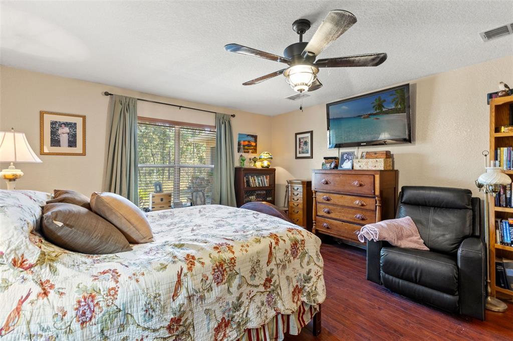 5 Boxleaf Court Homosassa, FL 34446 - Photo 22 of 58 a bedroom with a bed a couch and a flat screen tv