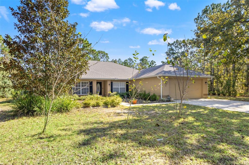 5 Boxleaf Court Homosassa, FL 34446 - Photo 3 of 58 a yellow house with a big yard and large trees