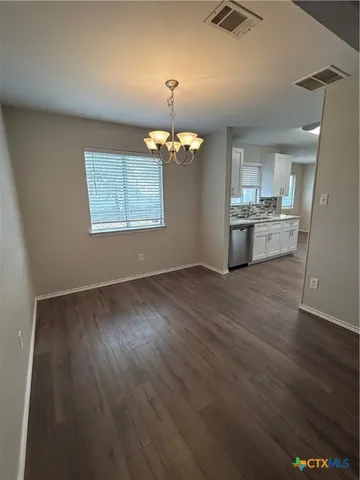 an empty room with wooden floor and staircase