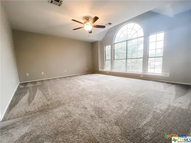 an empty room with windows and chandelier
