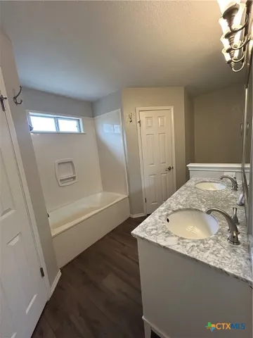 a bathroom with a granite countertop sink a toilet and bathtub