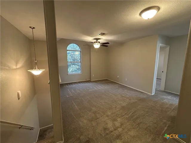 a view of a hallway with a chandelier fan