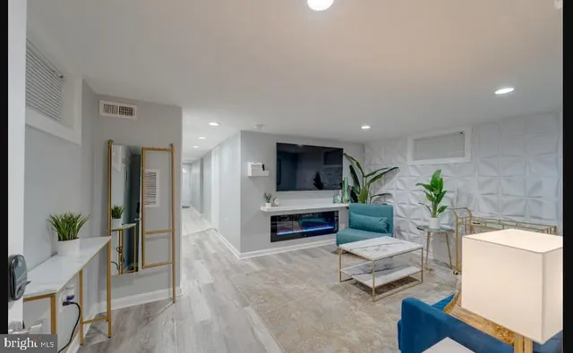 a living room with furniture a fireplace and a potted plant