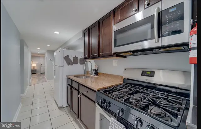 a kitchen with stainless steel appliances granite countertop a stove and a microwave